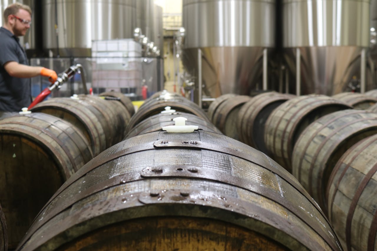 about-us Wooden barrels in a brewery for beer fermentation. Industrial setting.